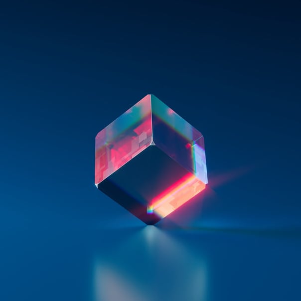 A transparent cube upright and balanced on a surface.